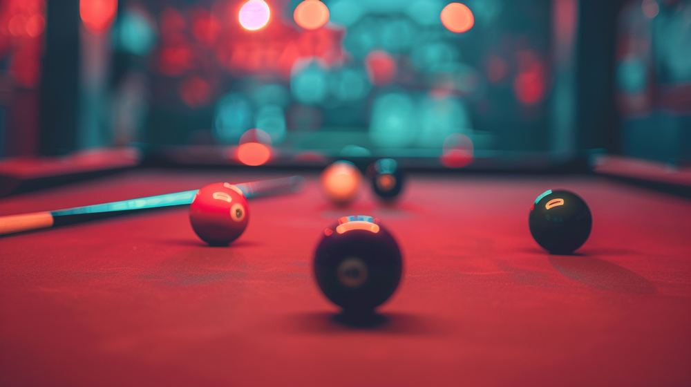 A close-up view of a pool table with several billiard balls and a cue stick, set in a dimly lit Games Room with red lighting and blurred colorful lights in the background.
